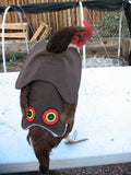 A chicken wearing a Custom Handmade Hen Saver Hen Apron/Saddle (Made in USA) costume on a table for protection.