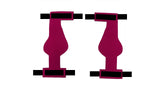 Two symmetrical, abstract magenta shapes are positioned vertically, side by side, and separated by a thin white gap. Black rectangles top and bottom frame the shapes, reminiscent of Birdy Bootie (Made in USA). The background is white.