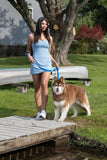 Waterproof dog collar, woman with brown Alaskan Malamute dog on a dock near water. 