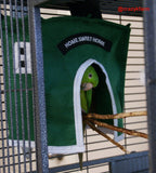 A parrot, a cozy pet bird, is sitting in a cage with a green Avian Haven Hut for Pet Birds.
